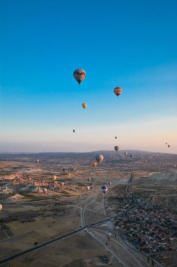 Kapadokya 'nın tuhaf dağları arasında gün doğumunda yükselen inanılmaz balonlar.