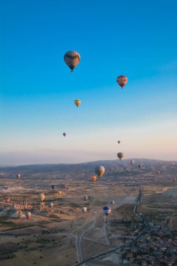 Kapadokya 'nın tuhaf dağları arasında gün doğumunda yükselen inanılmaz balonlar.