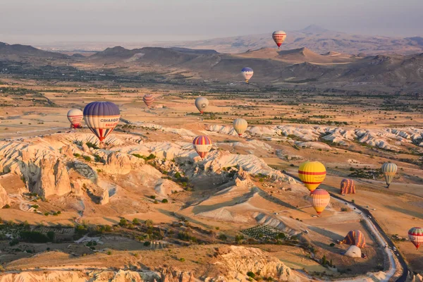 令人惊奇的气球在日出时分在奇异的卡帕多西亚山脉中飞舞 — 图库照片