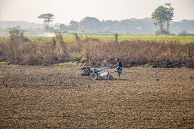 Kış mevsimlerinde traktörle tarla ekiyorlar. Bu resmi 17 Ocak 2022 'de Güney Asya, Bangladeş' ten çektim.