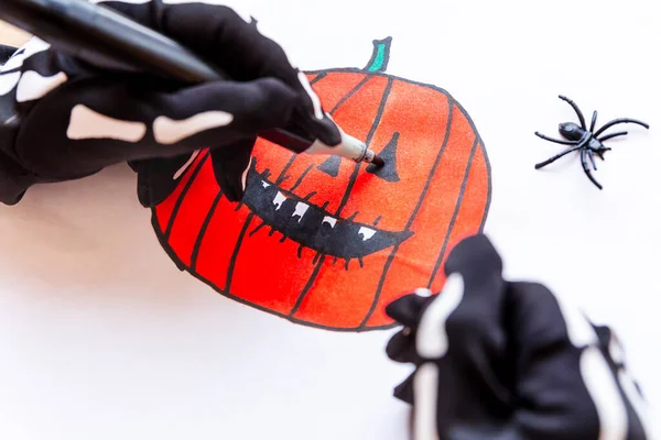 Hands drawing a toothy pumpkin for Halloween, close-up. — Stock Photo, Image