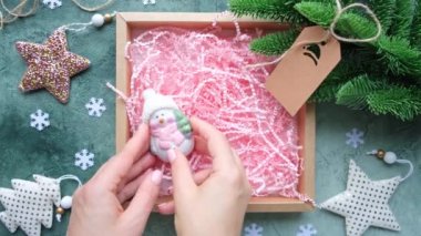 Noel oyuncaklarını hediye kutusuna koyan eller. Yeni yıl dekorasyonu, DIY hediye paketi.