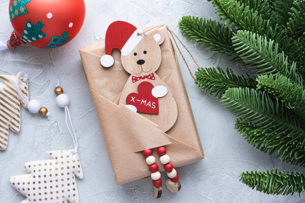 Рождественский подарок, украшения и еловая ветвь на светло-голубом фоне.