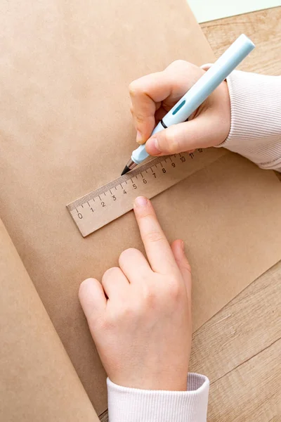 Close-up van de handen van het kind in het proces van schetsen met potlood op ambachtelijk papier. — Stockfoto