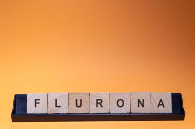 Flurona-Flurone. Coronavirus enfeksiyonu (Covid-19) ve grip aynı anda. Turuncu arkaplanlı ve metin için yeri olan mektuplar. Yatay fotoğrafçılık.