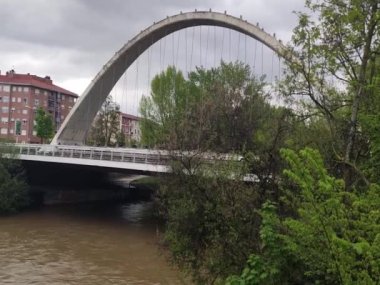 River. River Arga as it passes through Pamplona, in Navarra. River passing through a bridge. Cloudy day. Horizontal video.
