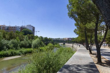 Madrid Rio Parkı. Manzanares nehrinin yanındaki Madrid Rio Parkı manzarası ve çevresindeki yeşil bitki örtüsü. Köprüleri ve yaya köprüleri olan yollar. İspanya 'da su püskürten fıskiyeler. Avrupa. Fotoğraf:.