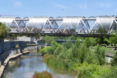 Madrid Rio Parkı. Manzanares nehrinin yanındaki Madrid Rio Parkı manzarası ve çevresindeki yeşil bitki örtüsü. Köprüleri ve yaya köprüleri olan yollar. İspanya 'da su püskürten fıskiyeler. Avrupa. Fotoğraf:.