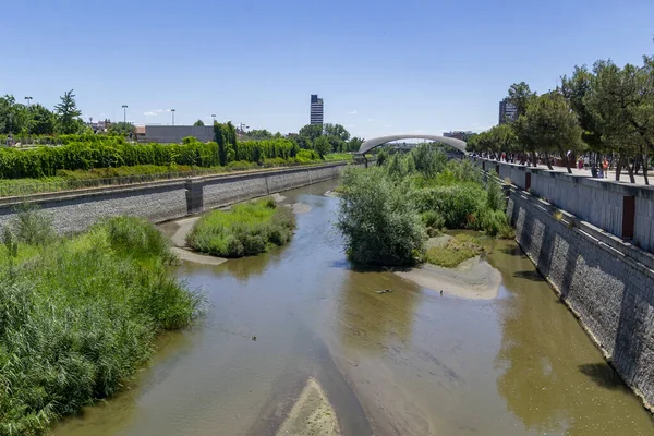 马德里里约公园观景马德里里约公园旁边的曼萨纳雷斯河和周围的绿色植被 有桥梁和人行天桥的道路 在西班牙 喷泉上有水柱 — 图库照片
