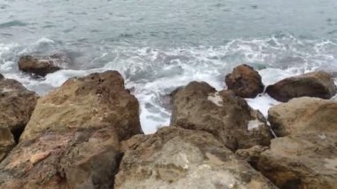 Waves. Sea. Waves of the Mediterranean breaking and splashing on the rocks of the municipality of Oropesa del Mar, in Castellon. Clear water. In Spain. Horizontal video. Vacation and relax.