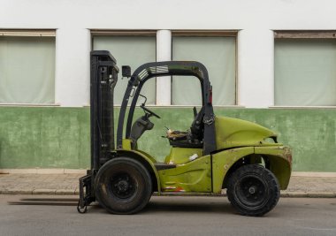 Llucmajor, İspanya; Ekim 03 2021: Endüstriyel bir caddeye park edilmiş yeşil forklift. Mallorca Adası, İspanya