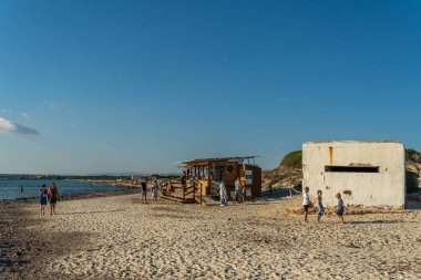 Es Trenc, İspanya; 11 Ekim 2021: İspanya iç savaşının eski sığınağı Es Trenc sahilinde, gün batımında, banyocuların yanında. Mallorca Adası, İspanya