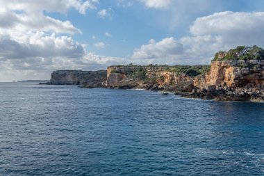 Bulutlu ve güneşli bir kış gününde Mallorca adasının kayalık kıyıları. S 'Almonia Koyu