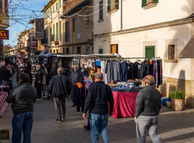 Llucmajor, İspanya; Ocak 07 2022: Majorcan kasabasındaki haftalık sokak pazarı. Coronavirus 'un Omicron versiyonunun kısıtlamalarından dolayı maskeli tedarikçiler ve müşteriler. Yeni normal