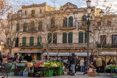 Llucmajor, İspanya; Ocak 07 2022: Majorcan kasabasındaki haftalık sokak pazarı. Coronavirus 'un Omicron versiyonunun kısıtlamalarından dolayı maskeli tedarikçiler ve müşteriler. Yeni normal