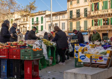 Llucmajor, İspanya; Ocak 07 2022: Majorcan kasabasındaki haftalık sokak pazarı. Coronavirus 'un Omicron versiyonunun kısıtlamalarından dolayı maskeli tedarikçiler ve müşteriler. Yeni normal