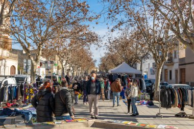 Llucmajor, İspanya; Ocak 07 2022: Majorcan kasabasındaki haftalık sokak pazarı. Coronavirus 'un Omicron versiyonunun kısıtlamalarından dolayı maskeli tedarikçiler ve müşteriler. Yeni normal