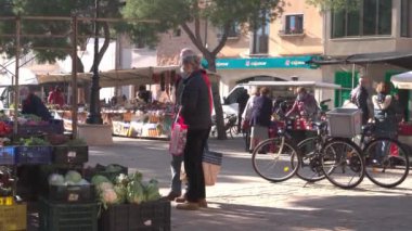 Campos, Spain; january 15 2022: Weekly street market in the Majorcan town of Campos. Vendors and customers with masks due to restrictions by the Omicron variant of Coronavirus. New normal