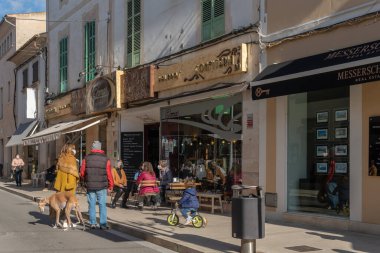 Campos, İspanya; 15 Ocak 2022: Ünlü Mallorcan pastanesinin ön cephesi Pomar, müşteriler maske takıyor. Yeni normal