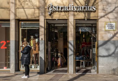 Manacor, İspanya; 20 Ocak 2022: Çok uluslu giyim ve aksesuar şirketi Stradivarius 'un ön cephesi, maske takan insanların olduğu güneşli bir sabah. Yeni normal