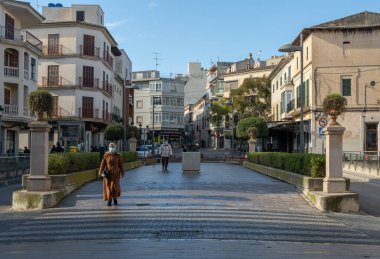 Manacor, İspanya; 20 Ocak 2022: Mallorcan 'ın Manacor kentinin tarihi merkezinde Passeig d' Antoni Maura 'nın genel görünümü. Sokaktaki maskeli insanlar. Yeni normal
