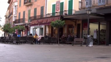 Manacor, İspanya; 20 Ocak 2022: Mallora 'nın Manacor kentindeki Sa Bassa Meydanı' nın manzarası, maske takan insanların kafeteryaların teraslarında oturması. Yeni normal