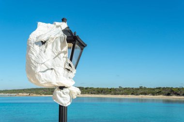 Mallorca 'daki bir otelin sokak lambası, kış mevsiminde kapanmak üzere beyaz plastikle kaplanmış. Otel işletmelerinin düşük mevsimde kapatılmasının kavramsal görüntüsü