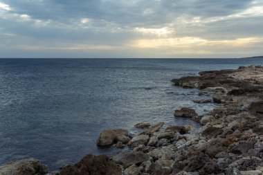Mallorca adasının kayalık kıyılarının manzarası, bulutlu bir günde, gün batımında, İspanya