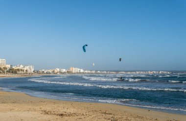 Playa de Palma de Mallorca 'nın genel manzarası. Rüzgarlı bir öğleden sonra, insanlar uçurtma uçuruyor.