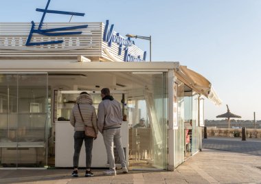Playa de Palma, İspanya; 23 Nisan 2022: Playa de Palma de Mallorca 'da gün batımında müşterilerin bulunduğu bir deniz ürünleri restoranının genel görünümü. Mallorca Adası, İspanya