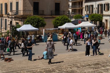 Felanitx, İspanya; 24 Nisan 2022: Majorcan 'ın Felanitx kentindeki haftalık tipik ürün ve el sanatları pazarının genel görünümü, güneşli bir sabah, insanlar cadde boyunca gezinirken