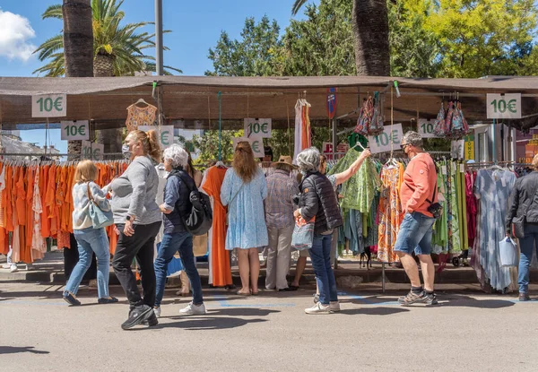 Felanitx, İspanya; 24 Nisan 2022: Majorcan 'ın Felanitx kentindeki haftalık tipik ürün ve el sanatları pazarının genel görünümü, güneşli bir sabah, insanlar cadde boyunca gezinirken