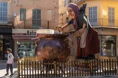 Manacor, Spain; may 14 2022: Giant sculpture of a folk tale character of the Majorcan culture, called rondalles, located in the street, as part of the Manacor Encantat festival. Witch with a cauldron