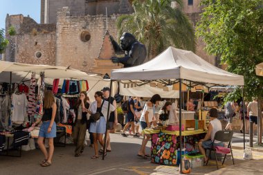 Santanyi, İspanya; Temmuz 09 2022: Majorcan kasabası Santanyi, İspanya 'da haftalık sokak pazarı. Dolaşan turistlerle giysi ve moda satan tezgahlar.