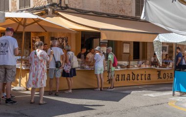 Santanyi, İspanya; Temmuz 09 2022: Mallorcan 'ın Santanyi kasabasında haftalık sokak pazarı. Ekmek ve şeker satan tezgah İspanya 'nın Mallorca adasının tipik bir örneği..