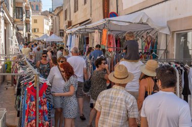 Santanyi, İspanya; Temmuz 09 2022: Majorcan kasabası Santanyi, İspanya 'da haftalık sokak pazarı. Dolaşan turistlerle giysi ve moda satan tezgahlar.