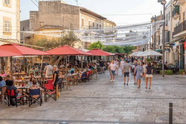 Santanyi, Spain; july 30 2022: Main street of the Mallorcan town of Santanyi, full of terraces of cafes and restaurants with customers at sunset