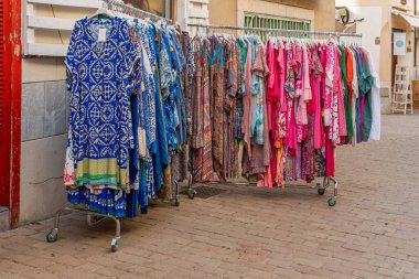 Arta, Spain; august 13 2022: Street stall selling colorful dresses in shades of blue and pink. Arta, island of Mallorca, Spain