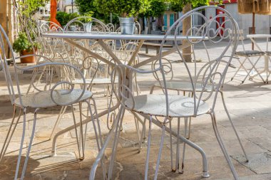 Close-up of vintage tables and chairs on the terrace of a coffee shop with no customers. Mallorca island, Spain