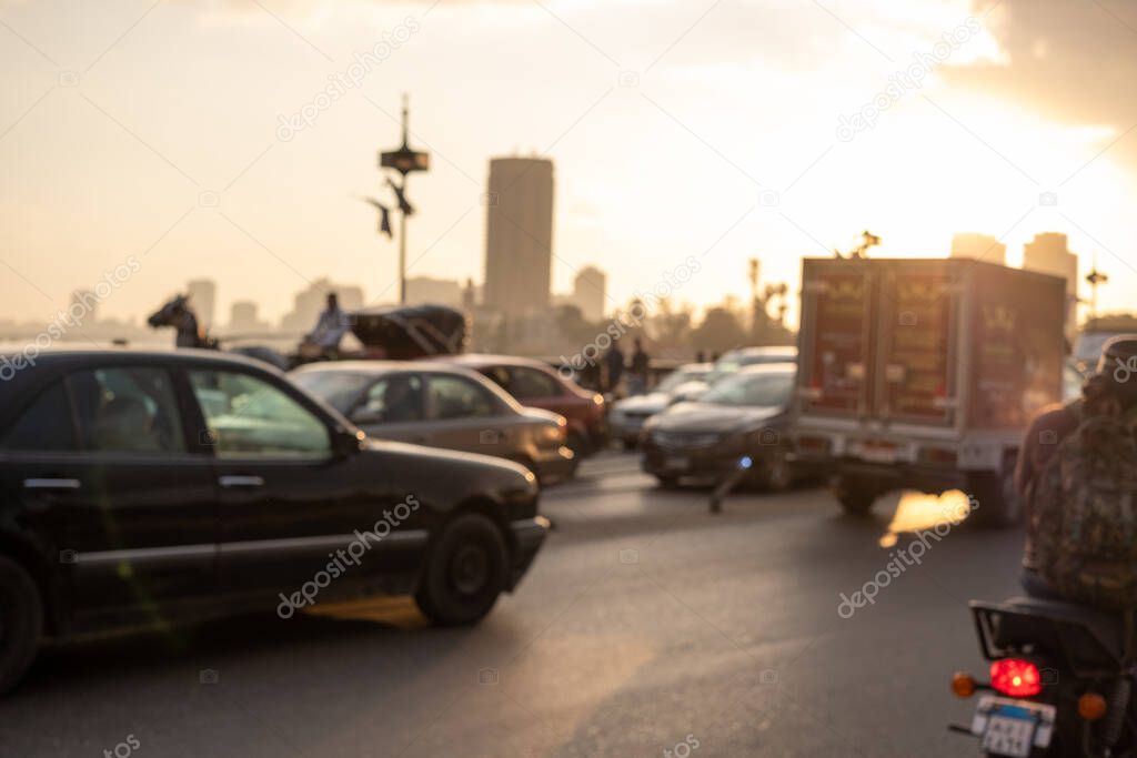 Out of focus view of a bridge in cairo at sunrise. Concepts of traffic issues and traffic jams, issues with overpopulation being solved by building new settlements