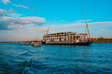 Lüks Mısır Ocak 2022. Lüks bölgede Nil nehri boyunca seyir halindeki bir gemi. Gezginler için ünlü Mısırlı turizm beldesi