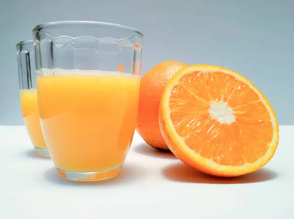 Orange juice with whole orange and slices