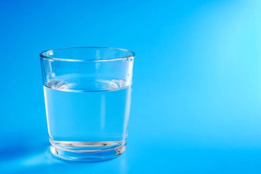 Mavi arka planda bir bardak temiz su. Boşluğu kopyala.