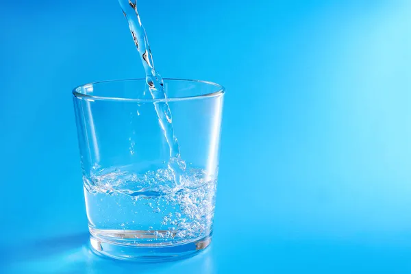 Despeje Água Limpa Vidro Sobre Fundo Azul Espaço Cópia — Fotografia de Stock