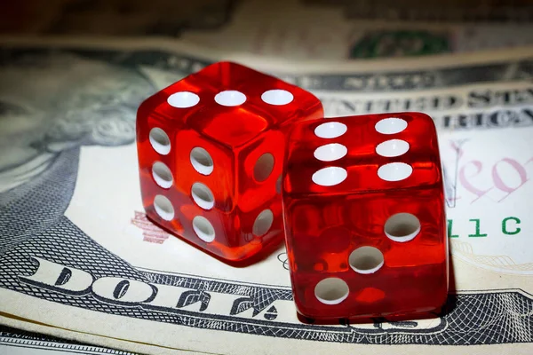 Sert ışığın altında iki kırmızı zar dolar üzerine banknot.