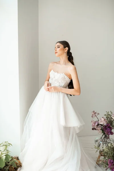 Wunderschöne, brünette Braut in einem weißen Luxuskleid posiert — Stockfoto