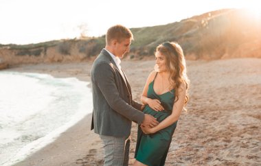 Deniz kıyısında sevgili kocasıyla birlikte gelecekteki genç anne..