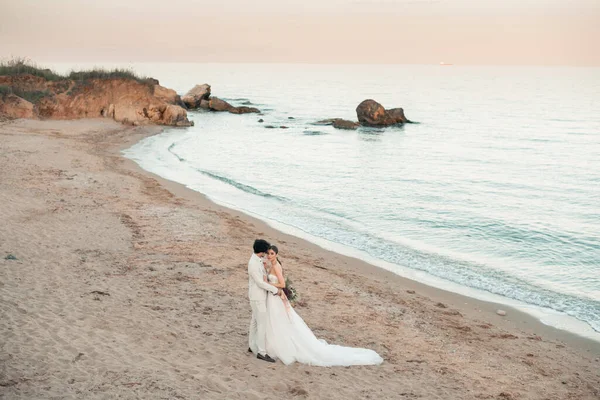 Pareja de boda, novio y novia en vestido de novia cerca del mar en la playa en el fondo —  Fotos de Stock