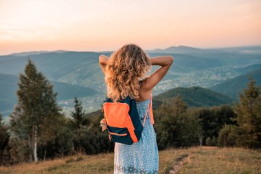 Kollarını kaldırıp poz veren kadın gezgin bakış açısıyla rahatlıyor. Mükemmel ince vücutlu kadın. Tatilde eğlenen bir bayanın portresi. Güzel manzara, seyahat