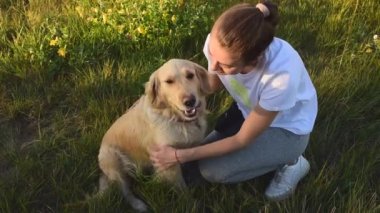 Parkta köpeği Golden Retriever ile oynayan genç bir kadın. Mutluluk ve dostluk. evcil hayvan ve kadın